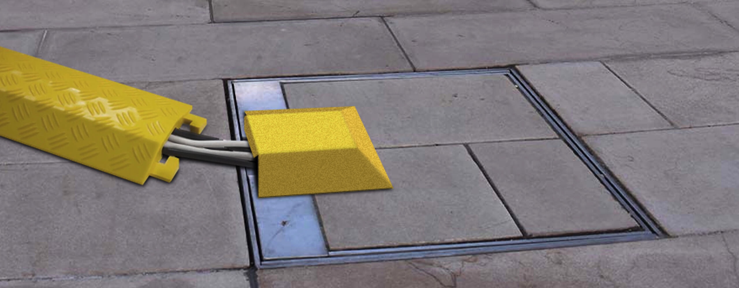 Image of an in-ground unit with hinged lid closed and locked with power cables covered by a cable protector